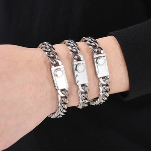Three silver stainless steel Cuban link bracelets with magnetic clasps on wrist