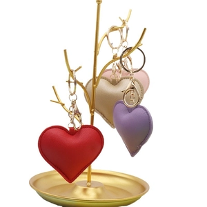 PU leather heart shaped keychains in red, purple, gold and pink on a display stand
