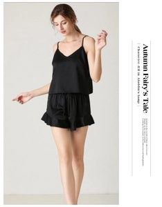 Detail view of black satin pajama set with V-neck camisole and ruffled shorts