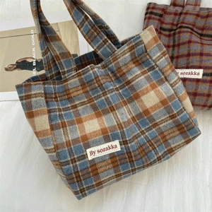 Flat lay view of vintage plaid tote bags in blue, orange, and red woven fabric