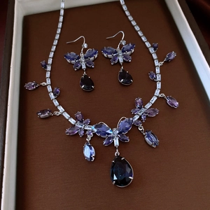 Details des silbernen Schmetterling-Schmucksets mit lila und blauen Edelsteinen