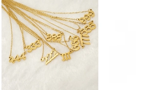 Macro shot of gold 111-999 number charms with cutout design on white velvet