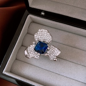 Vue détaillée d'une bague fleur vintage avec pierre carrée bleue et pétales de cristal
