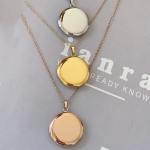 Detailed view of round locket necklaces in silver, gold, and rose gold finishes