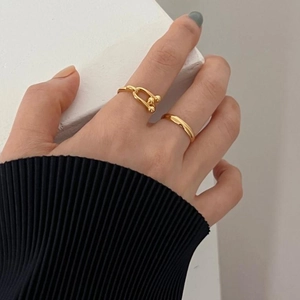 Close-up of gold 925 silver rings set with minimalist band and U-link chain design