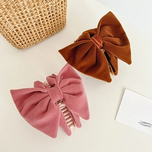 Detailed texture of velvet bow hair claws in dusty rose and caramel brown colors