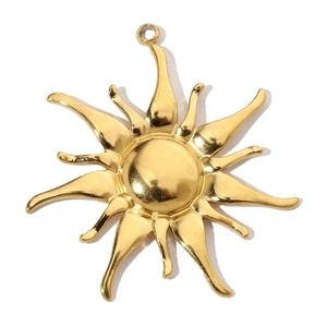Close-up of golden sun-shaped pendant in stainless steel with textured radial rays