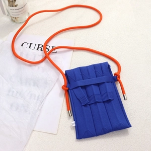 Nahaufnahme der blauen Strick-Handytasche mit orangefarbenem Seilschultergurt im Kontrast