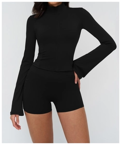 Close-up of a black slim-fit yoga jacket with zipper and matching high-waist sports shorts
