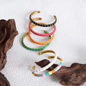 Chic enamel open bangles in candy colors stacked on wooden stand for women