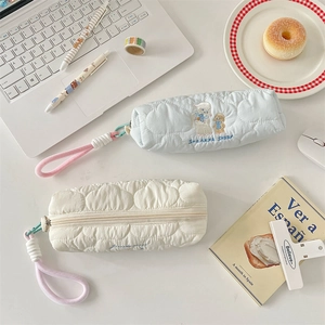 Close-up of soft quilted pencil cases with cute sheep embroidery and zipper detail