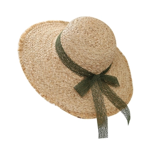 Wide brim raffia beach hat with dark green lace bow and frayed edge for summer vacations