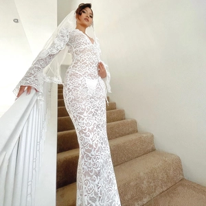 Detail of white lace maxi dress featuring long bell sleeves and a sheer floral texture