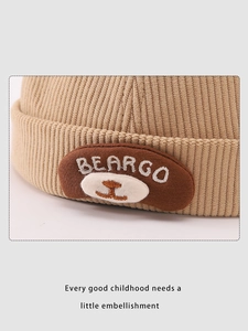 Detail of khaki corduroy fabric and bear embroidery on kids' docker brimless hat