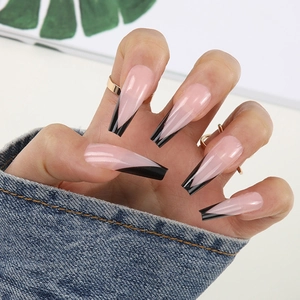 Detailed view of long ballerina press-on nails with nude pink base and black V-shaped tips