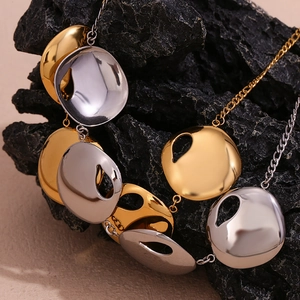 Detail of two-tone gold and silver irregular round pendant necklace on black stone