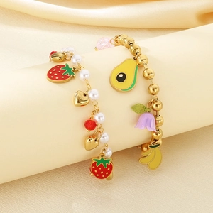 Detail of gold fruit charms including strawberries and avocado on pearl bracelets