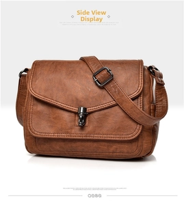 Detail view of brown vintage crossbody bag showing soft leather texture and metal lock