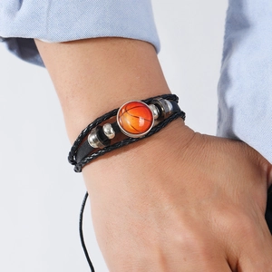 Détail d'un bracelet en cuir tressé noir avec pendentif basket-ball et perles argentées