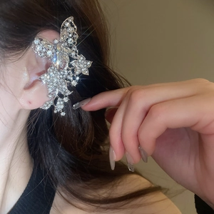 Close-up of sparkling silver butterfly ear cuff with rhinestones and tassel detail