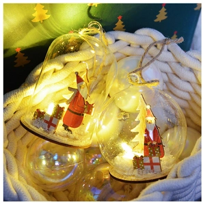 Detail of Christmas glass ball pendant with Santa figurine and warm LED lights inside