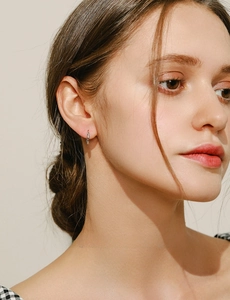 Close-up of S925 sterling silver rainbow hoop earrings on model with colorful stones