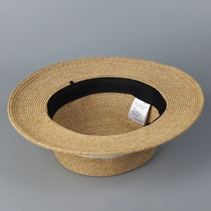 Vue détaillée de l'intérieur d'un chapeau de paille avec bandeau noir et étiquette 57,5cm