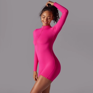 Detail of neon pink long sleeve athletic jumpsuit with high neck zipper and ribbed texture