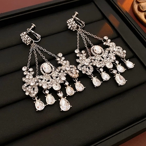 Detailed macro shot of silver flower earrings with sparkling rhinestone tassels and water drops