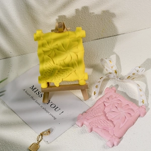 Detail von handgefertigten Gips-Anhängern mit Schmetterlingsrelief in Rosa und Gelb