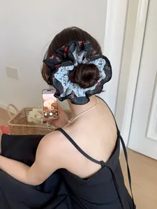 Détail de dos d'une femme portant un grand chouchou fleuri bordé de dentelle blanche