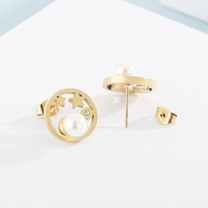 Détail de boucles d'oreilles rondes dorées avec étoiles, lunes et perles blanches