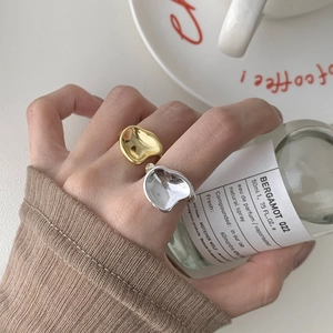Close-up of minimalist S925 silver irregular rings with gold and lava texture finish