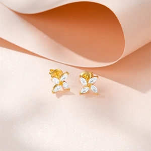 Macro shot of gold floral stud earrings featuring marquise-cut white cubic zirconia