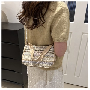 Détail d'un sac en paille tressée avec broderie papillon violet et bandoulière perle