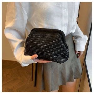 Close-up of black shell-shaped evening bag with dense bead texture and metallic clasp