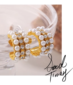 Detail shot of gold-plated hoop earrings with inlaid white pearls and sparkling crystals