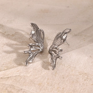 Detailed macro view of liquid metal 3D butterfly stud earrings in polished silver steel