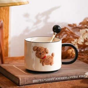 Hand-painted 3D puppy ceramic mug with black handle and spoon on vintage book background