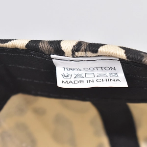 Close-up of 100% cotton fabric label on leopard print baseball cap with care symbols