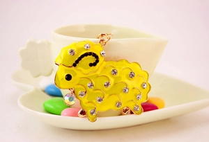 Detailed macro shot of yellow enamel sheep keychain with sparkling rhinestones decoration