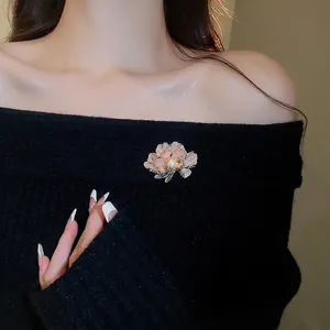 Elegant French style 3D pink flower brooch with a white pearl on a black sweater