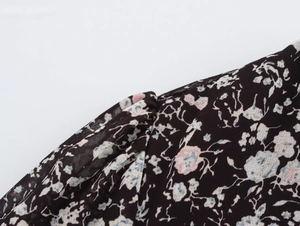 Close-up of floral print on black chiffon fabric showing shoulder seam detail