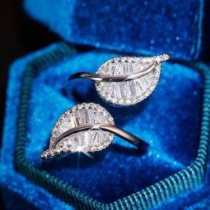 Macro view of silver leaf-shaped open ring with sparkling zircons in blue velvet box