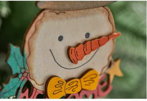 Detail of hand-painted wooden snowman ornament with a red Welcome sign and 3D nose
