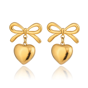 Detail of two-tone gold heart bow earrings with polished metallic finish and reflections