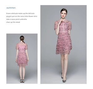 Détail d'une robe fleurie rose à volants avec col Claudine perlé et empiècement tulle