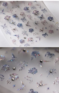 Macro view of iridescent rose and butterfly nail art stickers with rhinestone accents
