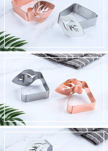 Detailed view of leaf-shaped stainless steel tablecloth clips in rose gold and silver