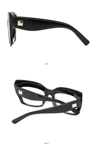 Detail view of black thick-frame glasses with gold square rivets on side and back